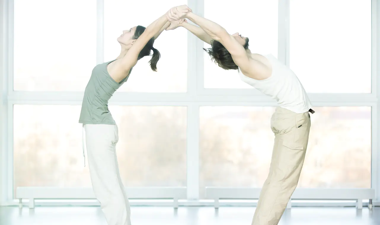 Foto de la página web de Noboli para la sección de rehabilitación. Dos personas estirándose juntas.